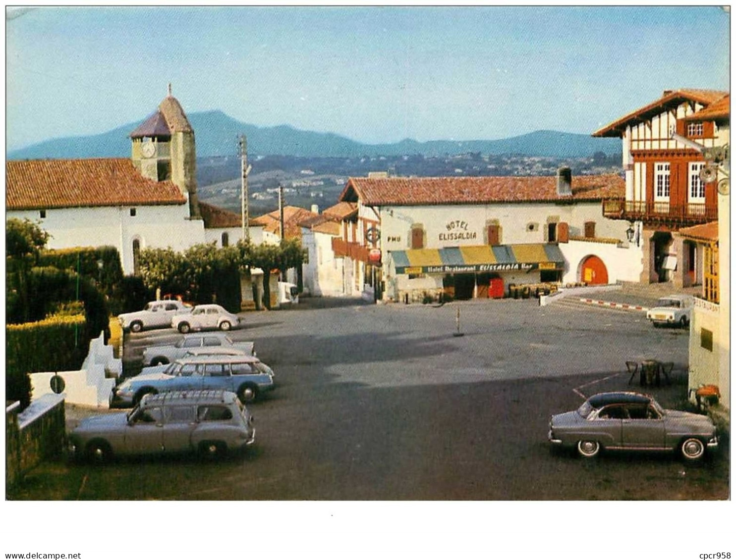 64.BIDART.n°26509.LA PLACE DE LA MAIRIE ET L'EGLISE.AU FOND LA RHUNE.VOITURES.CPSM - Bidart