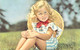 ENFANT - Fillette Blonde Au Chapeau Et Robe Rayée Bleue Assise Dans La Prairie - Noeud Rouge - Carte Postale Ancienne - Portraits