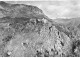 06 GOURDON AK#DC100 VUE AERIENNE GENERALE DE LA MONTAGNE MAISON ET EGLISE SUR LES ROCHERS - Gourdon