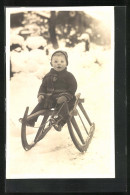 Foto-AK Kleiner Junge In Winterlicher Kleidung Auf Schlitten  - Wintersport