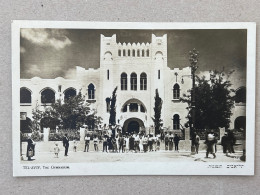 REAL PHOTO POSTCARD BY ELIAHU BROS - TEL AVIV, HERZL STREET AND THE GYMNASIUM. PALESTINE, ISRAEL - Palestina